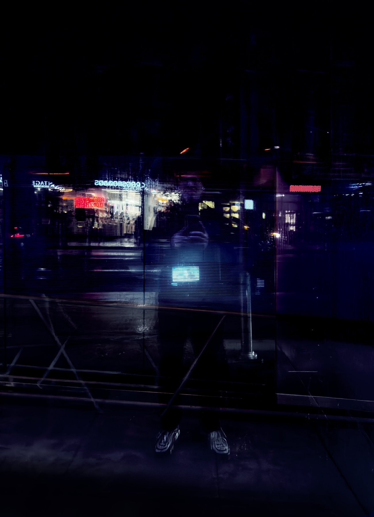 No End In Sight 156: The artist's faint reflection in a dark window at night, with red and blue neon signs and a glowing blue screen at his chest.